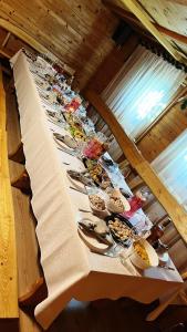 Atpūtas namiņš في Burtnieki: طاولة طويلة عليها أطباق من الطعام