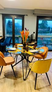 uma sala de jantar com uma mesa e cadeiras com flores em "Au Fil de la Charente" - Coeur de Saintes - WIFI Clim - Classé 4 étoiles - 4 pers em Saintes