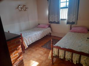 1 dormitorio con 2 camas y ventana en Cantinho da Lagoa en Araruama