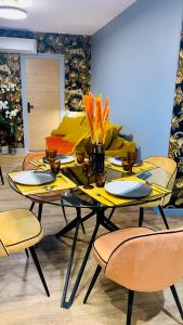 a dining room with a table with yellow chairs at "Au Fil de la Charente" - Coeur de Saintes - WIFI Clim - Classé 4 étoiles - 4 pers in Saintes