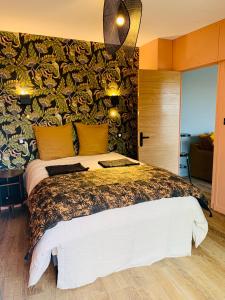 a bedroom with a king sized bed with a colorful wall at "Au Fil de la Charente" - Coeur de Saintes - WIFI Clim - Classé 4 étoiles - 4 pers in Saintes
