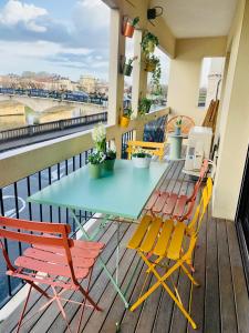 een tafel en stoelen op een balkon bij "Au Fil de la Charente" - Coeur de Saintes - WIFI Clim - Classé 4 étoiles - 4 pers in Saintes