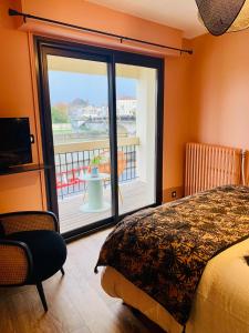 een slaapkamer met een bed en uitzicht op een balkon bij "Au Fil de la Charente" - Coeur de Saintes - WIFI Clim - Classé 4 étoiles - 4 pers in Saintes