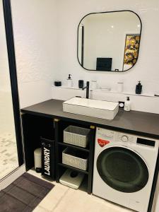 uma casa de banho com uma máquina de lavar roupa e um lavatório em "Au Fil de la Charente" - Coeur de Saintes - WIFI Clim - Classé 4 étoiles - 4 pers em Saintes