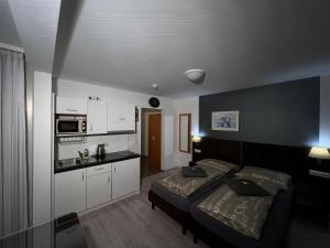 ein kleines Schlafzimmer mit einem Bett und einer Küche in der Unterkunft T24 - Ihr Appartement mit Charakter in Sindelfingen