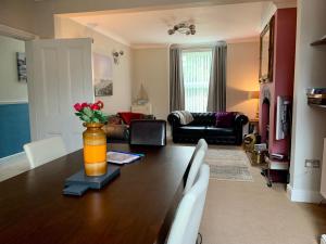 a living room with a wooden table with a vase with flowers at Smart & Comfortable 3-bedroom Victorian house in Stalham
