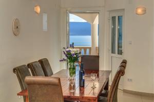 a dining room table with a vase of flowers on it at Villa Katarina in Stanići