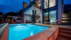 a swimming pool in front of a house at Villa Skrisia in Cesarica