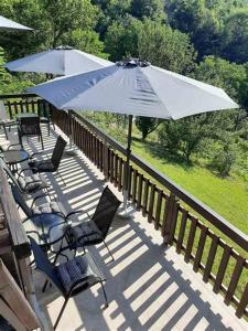 a group of chairs and an umbrella on a deck at Vila Kula in Crni Vrh