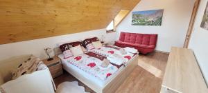 a bedroom with a bed and a red chair at chalupa Český štít Vysoké Tatry in Stará Lesná