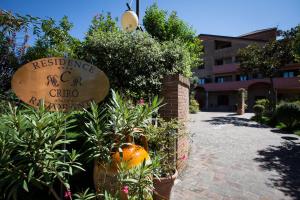 a sign for a hotel with a pumpkin and plants at Residence Criro in Marina Palmense