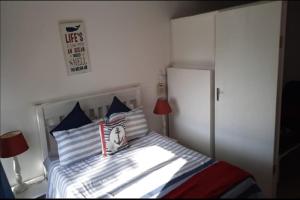 ein kleines Schlafzimmer mit einem Bett mit einer weißen Wand in der Unterkunft St Lucia Villa Mia 11 in St Lucia