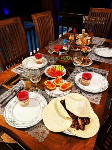a wooden table with plates of food on it at Villa Green Ice in Galle