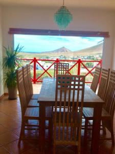 a wooden table and chairs with a view of the ocean at Casa Yahshua in Villaverde