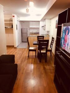 een woonkamer en een keuken met een tafel en stoelen bij Hermoso Departamento a media Cuadra de la Av Javier Prado in Lima