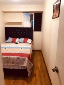 een kleine slaapkamer met een bed in een kamer bij Hermoso Departamento a media Cuadra de la Av Javier Prado in Lima