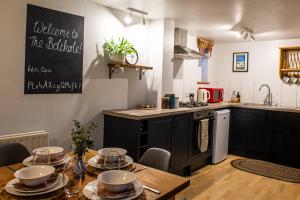a kitchen with a table with dishes on it at The Bolthole barn with wood-fired hot tub in Glentworth