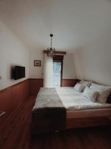 um quarto com uma cama grande e uma janela em Vila Jelena em Jahorina
