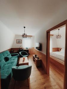 a living room with a green couch and a bed at Vila Jelena in Jahorina