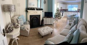 a living room with a fireplace and a christmas tree at TJ’s Cottage in Enniskillen