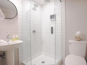 a bathroom with a shower with a toilet and a sink at Basecamp Suites Banff in Banff