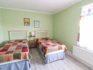 two beds in a room with green walls at The Dormie House in Silloth