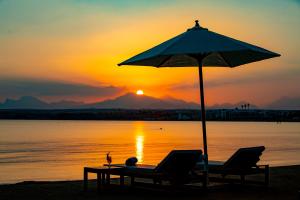 a beach with two chairs and an umbrella at Zen Resort Sahl Hasheesh by TBH Hotels in Hurghada