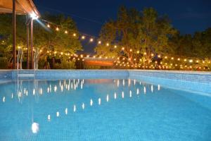 una gran piscina con luces encendidas por la noche en Dream garden, en Karbi