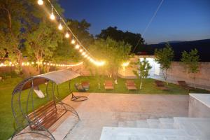 a patio with a bench and lights at night at Dream garden in Karbi