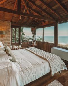 a large white bed in a room with windows at Pousada Caminho do Rei in Praia do Rosa +191 photos