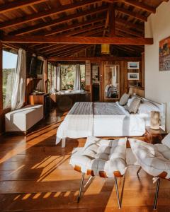 ein Schlafzimmer mit einem großen Bett und zwei Stühlen in der Unterkunft Pousada Caminho do Rei in Praia do Rosa + 175 Fotos