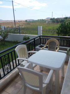 a white table and chairs on a balcony at Irini's appartment in Néa Koútali