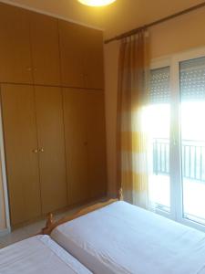 1 dormitorio con cama y ventana en Irini's appartment en Néa Koútali