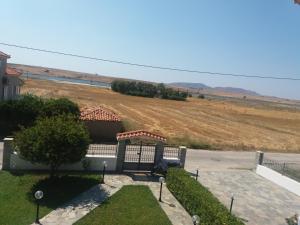 uma vista para um campo a partir de uma casa em Irini's appartment em Néa Koútali