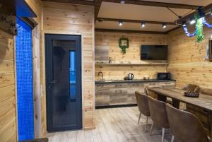 a kitchen with wooden walls and a table and chairs at Готель Otelnov in Poltava