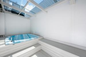 a bath tub in a white room with a window at Ashleigh Court Motel in Rotorua