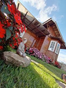 a statue sitting on a rock in front of a house at Casa de madeira em Lavras Novas in Lavras Novas +10 photos
