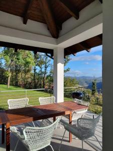 una mesa de madera y sillas en un patio con vistas en Pool Villa with view on the Langhe hills, en Mango