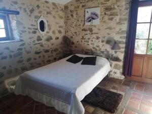 a bedroom with a bed with two pillows on it at AUBERGE LA BOUCHOLIERE in Parthenay