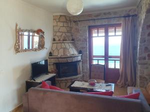 a living room with a couch and a fireplace at Nireas : Stone Villa in Zakynthos Town