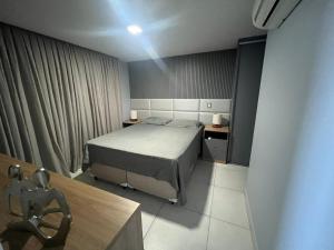 a bedroom with a bed and a table and a chair at Apto Joao Pessoa/Cabedelo in Cabedelo