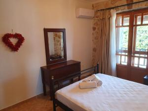 a bedroom with a bed and a mirror and a window at Nireas : Stone Villa in Zakynthos