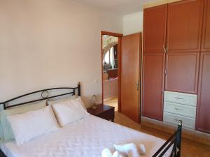 a bedroom with a bed and a dresser and a closet at Nireas : Stone Villa in Zakynthos