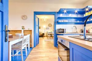uma cozinha azul com um lavatório e um balcão em Chalupa Česká Kanada em Dobrohoř
