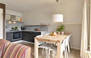 een keuken met een houten tafel en een aantal stoelen bij Awesome Home In Vlagtwedde With Kitchen in Vlagtwedde