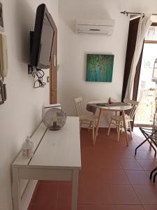 a living room with a table and a tv on the wall at Casa Miele Ortigia in Syracuse