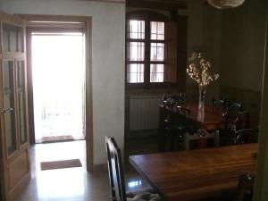una sala da pranzo con tavolo, sedie e finestra di Casa Rural El Saúco a La Vellés