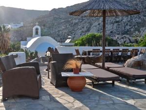a patio with chairs and tables and an umbrella at VILLA ALEXANDROS in Naousa +16 photos