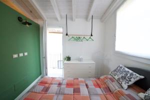 um quarto com uma cama e uma parede verde em La brezza del lago em Marone