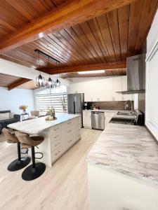 a large kitchen with white cabinets and a wooden ceiling at ! 5 Bed Beautiful Home with Fenced Yard & Hammock! WEM - Foosball Table - WiFi - Fireplace - Long Stay in Edmonton